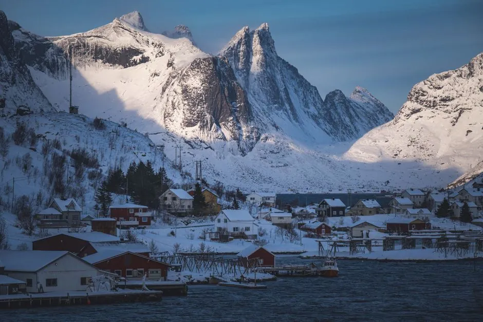 Picturesque winter scene of snow-covered mountains and fishing village in Lofoten.
